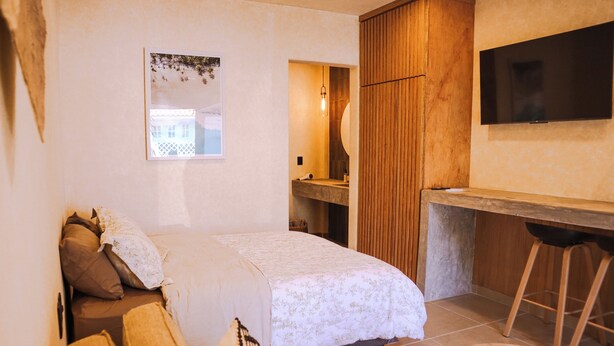 Un dormitorio con cama, escritorio y televisor.