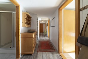 A hallway with a wooden cabinet, a red rug, and framed pictures on the wall. - Füchsle holiday flat with mountain views in Wildhaus (Wildhaus)
