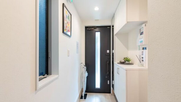 A narrow hallway with a door at the end, a radiator, and a small shelf with a plant. - Popular Shinjuku area Maximum12 People (Tokyo)