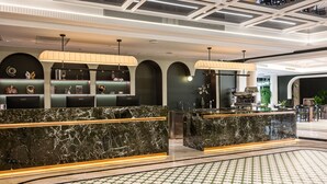 A modern hotel lobby with marble reception counters, a patterned floor, and a ceiling with recessed lighting. - Vishan Garden Boutique Hotel (Xiamen)