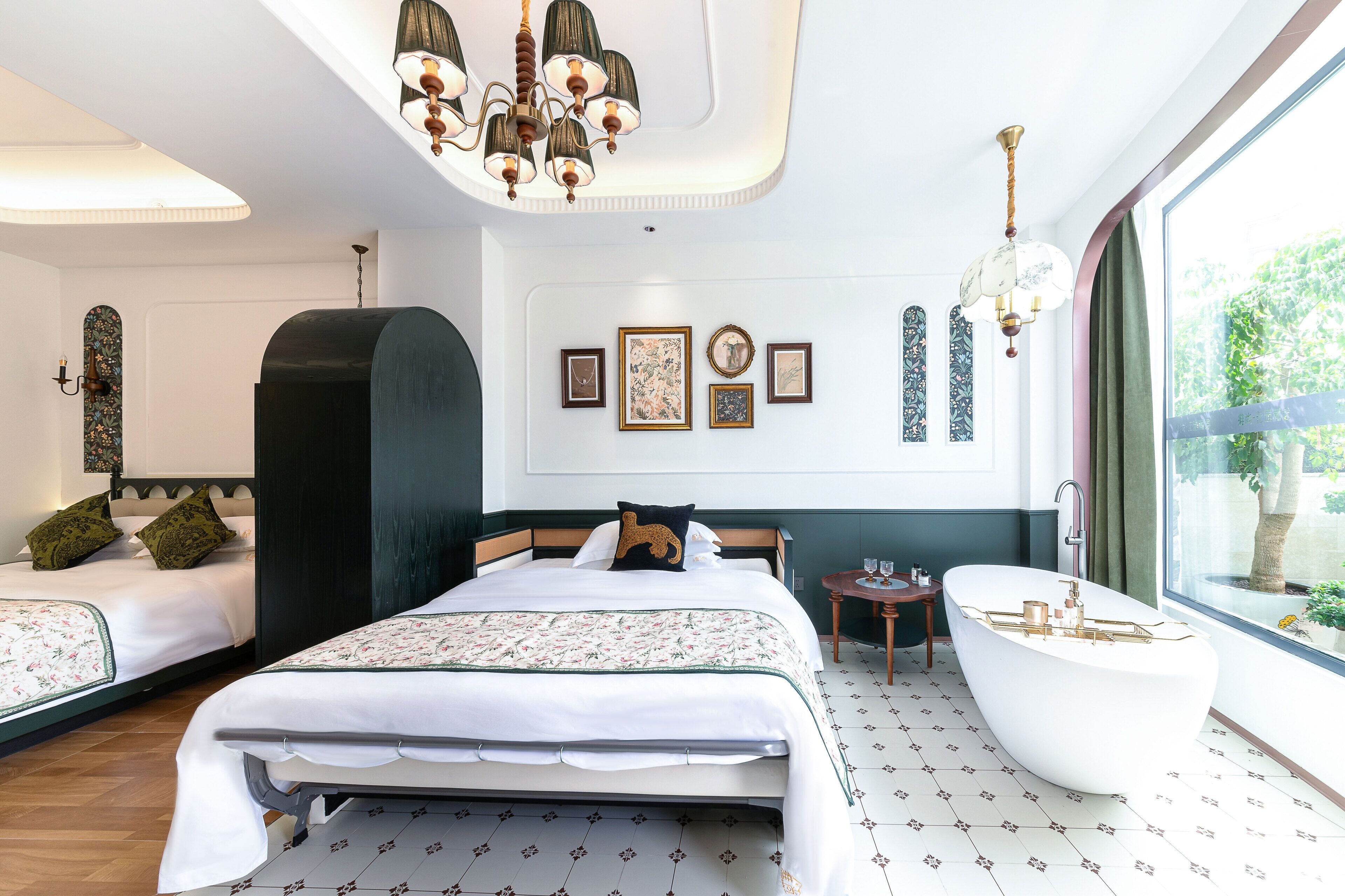 A hotel room with a large bed, a bathtub, and a large window with a view of greenery.