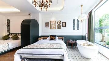 A hotel room with a large bed, a bathtub, and a large window with a view of greenery.