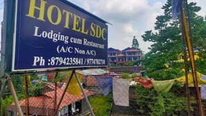 Une enseigne indiquant « HÔTEL SDC », ce qui signifie qu’il s’agit d’un établissement proposant à la fois des chambres et un restaurant.