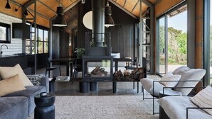 A modern interior with a fireplace, sofas, and a kitchen area.