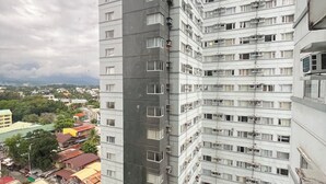 Een hoog gebouw met meerdere balkons en een zwembad.