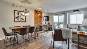 Een moderne woonkamer met een open haard, eethoek en een bank.