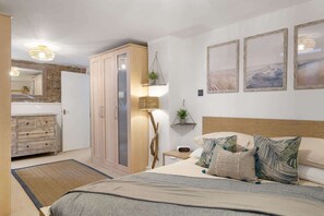Ein Schlafzimmer mit Bett, Nachttisch und Schrank. Ein Kleiderschrank mit Spiegel und einer hängenden Pflanze ist ebenfalls vorhanden.