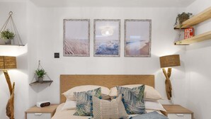 Een slaapkamer met een houten hoofdbord, een bed met meerdere kussens, nachtkastjes met lampen, en drie ingelijste foto's aan de muur.