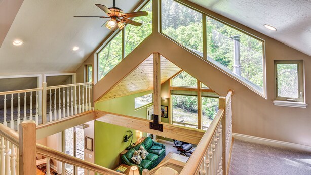 Un loft spacieux avec de hauts plafonds, de grandes fenêtres et un escalier en bois.