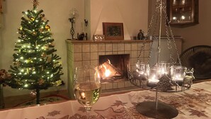 Un salon chaleureux avec une cheminée, un sapin de Noël et un chandelier.