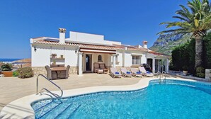 A white villa with a swimming pool, outdoor seating, and a view of the sea. - Casa Esmick - Denia, Costa Blanca (Denia)