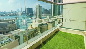 A high-rise building with a view of a city skyline and a body of water. - Bloomfeilds Royal 1Br Skyscraper (Abu Dhabi)