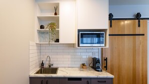 Eine moderne Küche mit eingebauter Mikrowelle, einem Spülbecken und Holzschränken.
