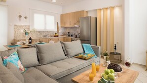 Chambre Quadruple Deluxe, vue piscine | Coin séjour | TV connectée de 58 pouces avec chaînes numériques, console de jeux vidéo