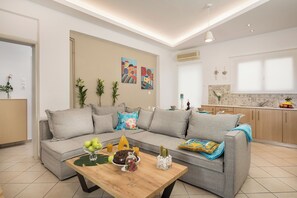 Deluxe Quadruple Room, Pool View | Living area | 58-inch Smart TV with digital channels, video-game console - luxsuites (Chania)