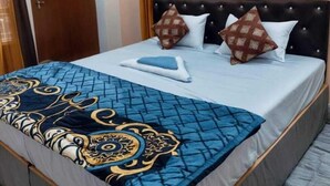 A bedroom with a bed, a wooden door, and curtains. - Shree Guest House (Varanasi)