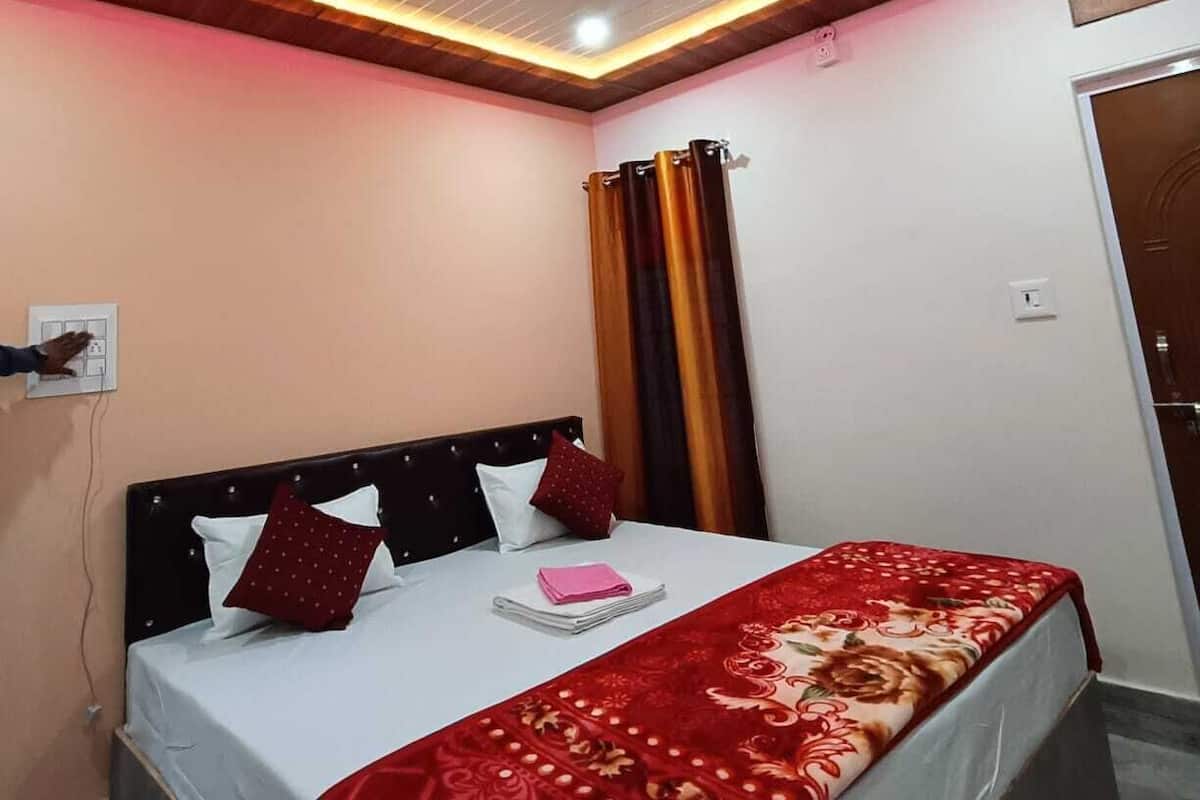 A bedroom with a bed, a ceiling fan, and a wall-mounted light fixture.