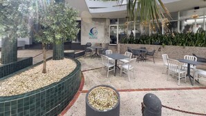 Un espace extérieur aménagé en terrasse, avec des sièges et un petit arbre.