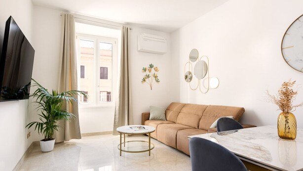 Un salon moderne avec un canapé, une table basse et un téléviseur.