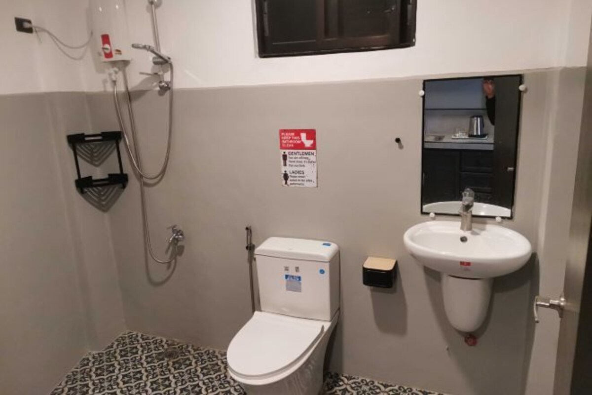 A small bathroom with a toilet, a sink, and a shower.