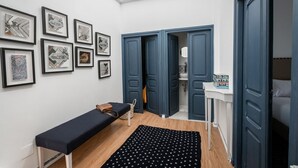 A room with a bench, a patterned rug, and a wall with framed artwork. - La Villa Des Oliviers (Site archéologique de Carthage)