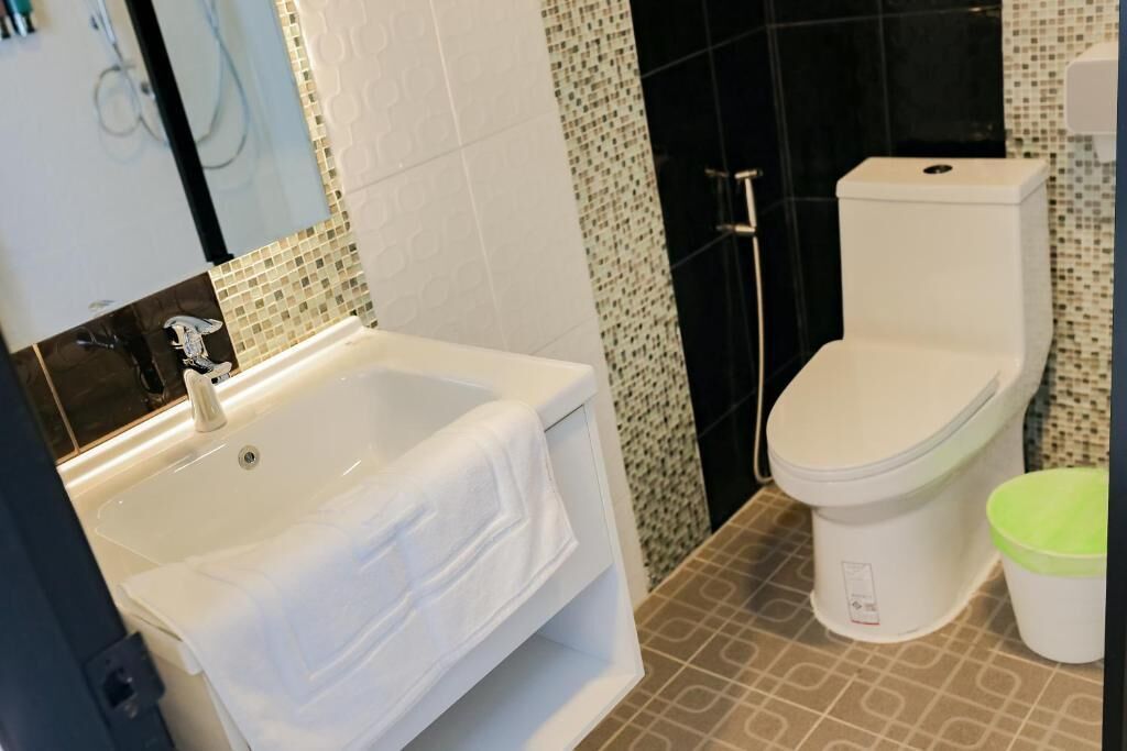 Un baño con lavamanos blanco, inodoro y zona de ducha.