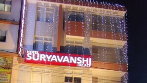 Un hôtel appelé « Suryavanshi Palace », avec une entrée dallée et une moto garée devant.
