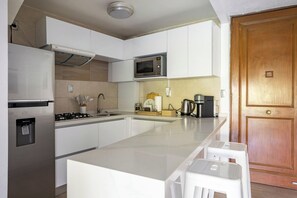 Vista de la cocina y entrada principal. Con varios cajones y gabinetes para guardar los esenciales - Cozy 2-bedroom apartment in vibrant Ciudad de México with WiFi (Ciudad de México)