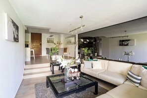 A modern living room with a glass coffee table, a sofa, and a dining area with chairs. - Cozy 2-bedroom apartment in vibrant Ciudad de México with WiFi (Ciudad de México)