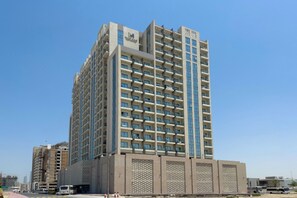 A multi-story hotel with a modern design, featuring a prominent logo on the facade. - Bloomfields Cozy STU Farishta Alfurjan  (Dubai)