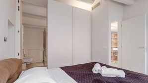 Ein Hotelzimmer mit Bett, Badezimmer und begehbarem Kleiderschrank.