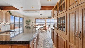 Une cuisine spacieuse avec des meubles en bois, un grand îlot central et une vue sur l’extérieur.