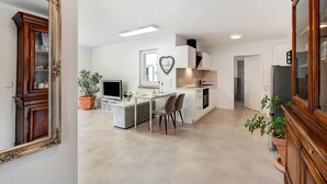 Une cuisine moderne avec un îlot central, des meubles blancs et une décoration en forme de cœur sur le mur.