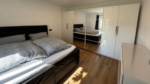 Ein Schlafzimmer mit einem Bett, einem Kleiderschrank und einem Spiegel.