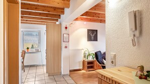 A room with wooden beams, a radiator, a plant, a radio, and a framed certificate on the wall. - Apartment 'Schillingblick' with Shared Garden, Balcony and Wi-Fi (Titisee-Neustadt)