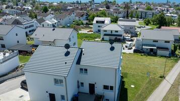 Un quartier résidentiel avec des maisons modernes, une église et un lac en arrière-plan.