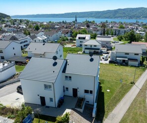 Un quartier résidentiel avec des maisons modernes, une église et un lac en arrière-plan.