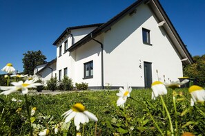A modern two-story house with a white exterior, multiple windows, and a sloped roof. - Apartment 'Waldhaus' with Mountain View, Balcony and Wi-Fi (Schmallenberg)