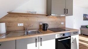 Une cuisine moderne dotée d’un plan de travail en bois, d’un évier en acier inoxydable et d’un four encastré.