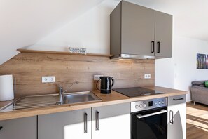Eine moderne Küche mit Holzarbeitsplatte, Edelstahlspüle und eingebautem Backofen.
