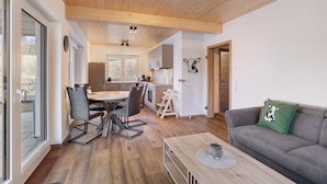 Um interior moderno com área de jantar, cozinha e sala de estar.