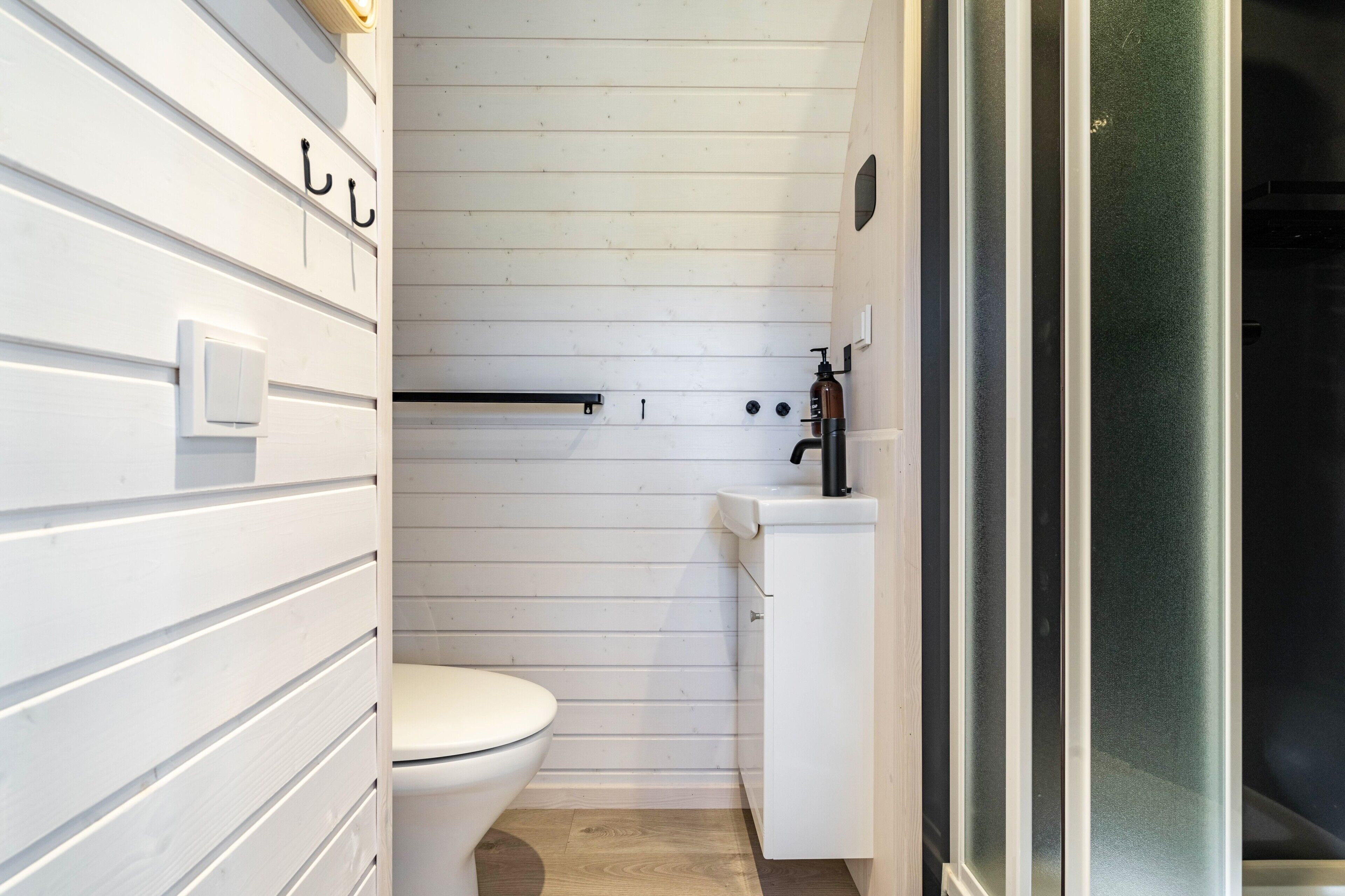 Un bagno compatto con il WC, un lavandino e una zona doccia.