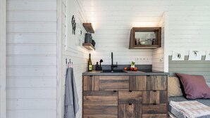 Een compacte keuken met houten keukenkastjes, een ingebouwd spoelgedeelte en een klein aanrecht.
