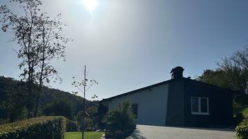 A paved pathway leading to a modern building with a flat roof and a window.