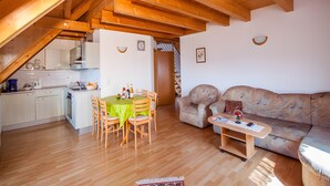 A cozy attic room with a dining table, chairs, a sofa, and a small coffee table. - Apartment 'C' with Lake View, Balcony and Wi-Fi (Meersburg)