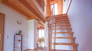 A wooden staircase leading to an upper level, a wooden floor, a shelf with items, and a window. - Apartment 'A' with Lake View, Balcony and Wi-Fi (Meersburg)