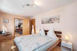 Une chambre à coucher avec un lit, une table de chevet, une lampe et un tableau au mur.