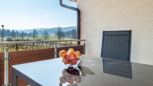 A table with a bowl of fruit and a view of a vineyard. - Apartment 'Apfelschnitz' with Shared Garden, Balcony and Wi-Fi (Stockach)