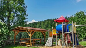 A playground with a slide, climbing net, and a picnic table. - Apartment 'Fichte' with Shared Garden, Balcony and Wi-Fi (Titisee-Neustadt)