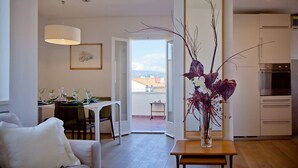 A modern living room with a dining area, a large mirror, and a view of the outdoors.